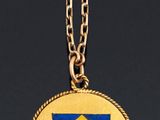 a close up of a necklace with a yellow and blue diamond on it