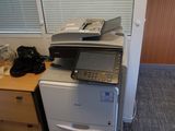 une imprimante posée sur un bureau, à côté d'un téléphone