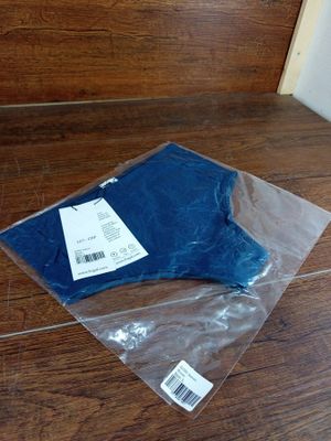 un sac en tissu bleu posé par terre à côté d'une paire de ciseaux
