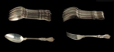 Plusieurs fourchettes et cuillères sont disposées en rangée sur un fond noir.