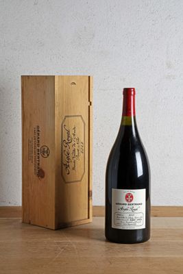 a bottle of wine sitting next to a wooden box