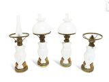 three white glass and brass table lamps on a white background