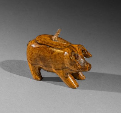 wooden figurine of a pig on a gray surface