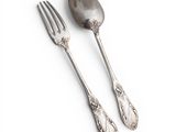 two silver spoons and a fork on a white surface