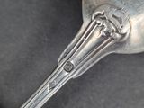 a silver spoon with a bird on it on a black surface