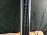 an electric fan sitting on top of a wooden table next to a black wall