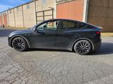 the tesla model 3 is parked on the side of the road