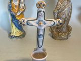 three figurines of jesus and a cup of coffee on a table