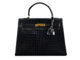 a black crocodile skin handbag on a white background