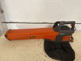 a close up of a chainsaw sitting on a floor near a wall