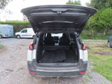 the back of a car with its trunk open on a gravel road