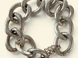 un bracelet à chaîne en argent avec un fermoir, sur fond blanc