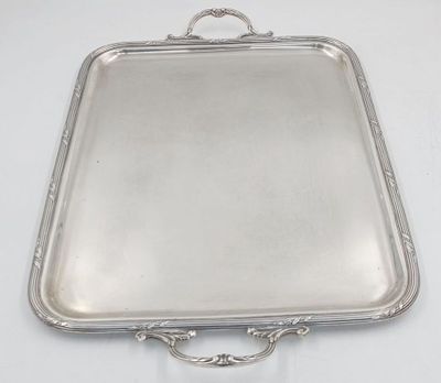 an antique silver tray with handles on a white table