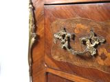 a close up of a wooden cabinet with brass handles