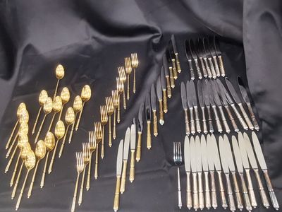 a lot of silver and gold forks and spoons