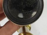 a person holding a gold colored telescope in their hand
