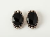 a pair of black onyx stone earrings on a white surface