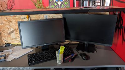 a desk with two monitors and a keyboard on it