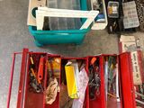 un grand nombre d'outils dans une boîte rouge posée sur le sol