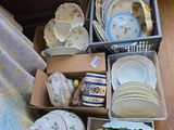 beaucoup d'assiettes et de tasses dans des cartons posés par terre