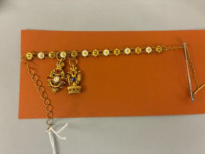 un bracelet en or orné d'une couronne et d'une chaîne
