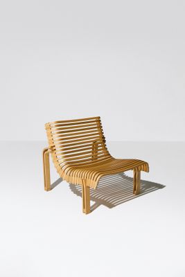 une photo d'une chaise longue en bois posée sur un sol blanc