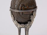 a metal egg holder that has a bird ' s feet on it
