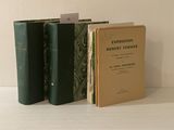 trois livres posés sur une table blanche, avec une carte devant eux