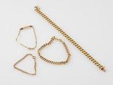 two pieces of gold jewelry on a white surface