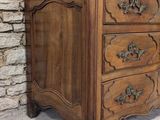 an image of a wooden chest of drawers against a stone wall