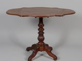 une table en bois avec un plateau en forme de fleur, posée sur un piédestal