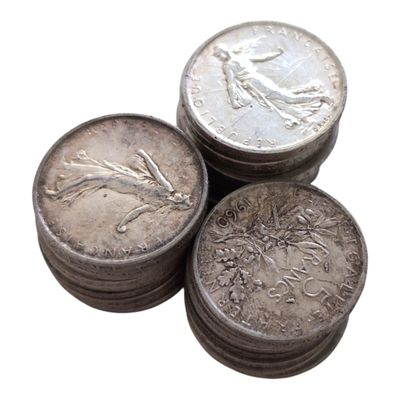 trois pièces d'argent posées l'une sur l'autre sur une surface blanche