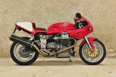 une moto rouge garée devant un mur