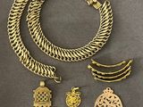 une collection de bijoux en or comprenant une hamsa, une croix et un pendentif