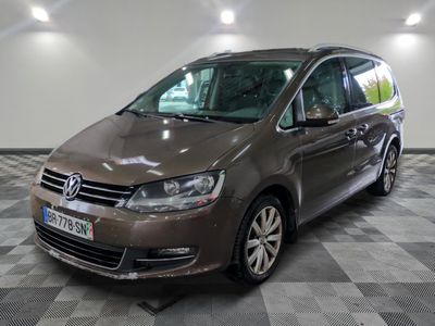 La camionnette marron est garée dans le garage, sur un sol à damier.