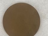 the bottom of a round metal object on a white surface