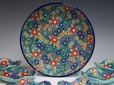 five bowls and six plates with a floral design on them