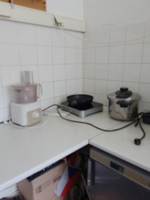 a small kitchen with a stove, microwave, toaster, and other appliances