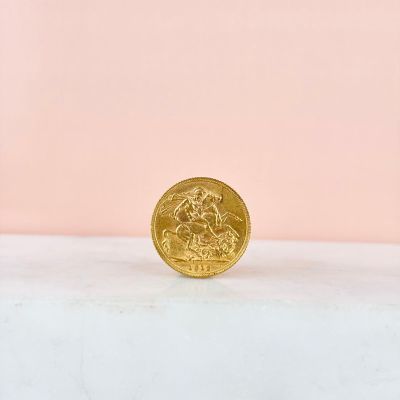a gold coin sitting on top of a white surface