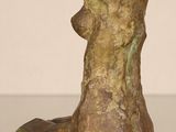 statue of a dog sitting on a table with its head resting on a rock