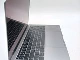 a silver laptop with a black keyboard on a white surface