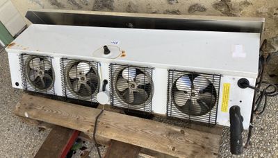 trois ventilateurs posés sur une palette