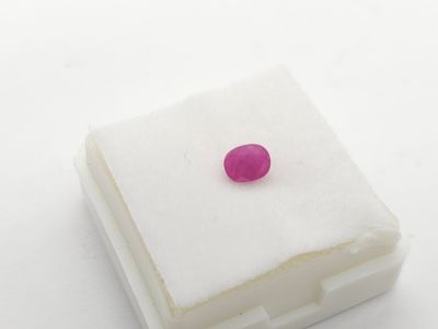 une pierre rose posée sur un morceau de papier blanc
