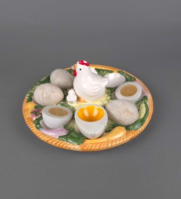 une assiette sur laquelle se trouvent des œufs, des coquilles d'œufs et un poulet