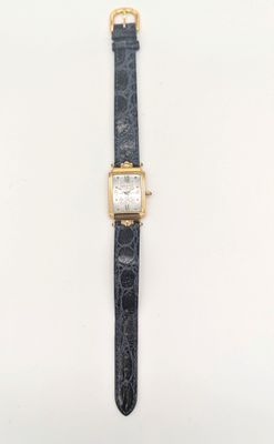 une montre en or avec un bracelet en cuir noir et un cadran blanc