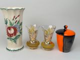 three vases and two glasses sitting next to each other