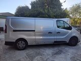 a silver van parked in a driveway next to a house