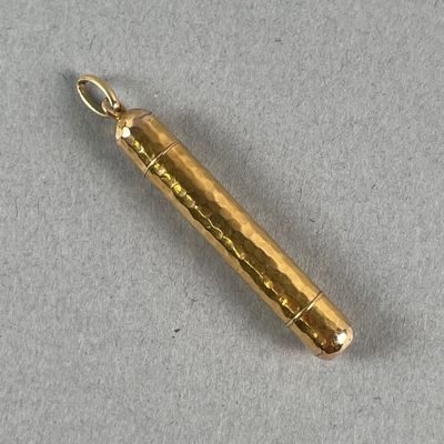 a gold colored metal object on a gray surface