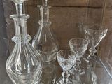 une table en verre avec de nombreux verres à vin et une carafe