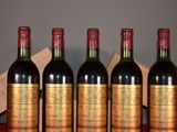 four bottles of wine sit on a table next to a wooden box